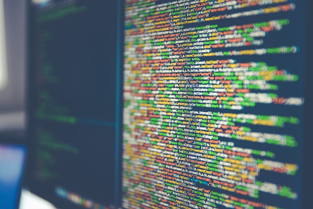 Close-up of colorful computer code on a screen, featuring lines of programming text against a blurred, dark background, conveying a tech-focused mood.