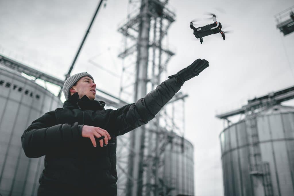 A person in a beanie launches a drone for drone construction site monitoring hudson valley.